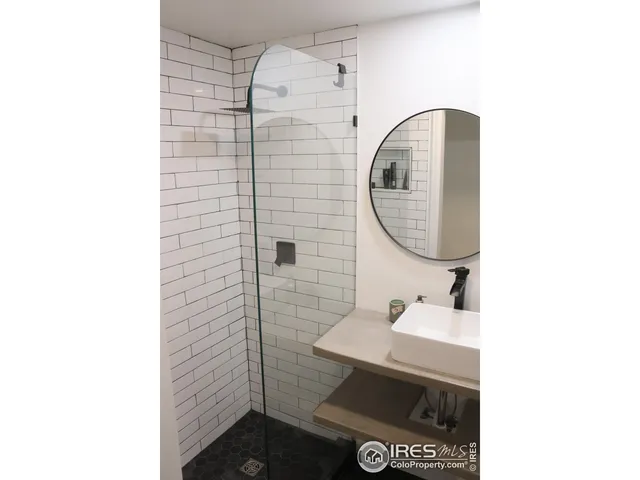 a bathroom with a sink a mirror and a shower