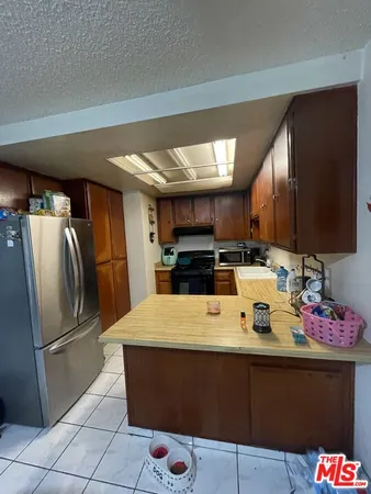 a kitchen with stainless steel appliances granite countertop a sink refrigerator and cabinets