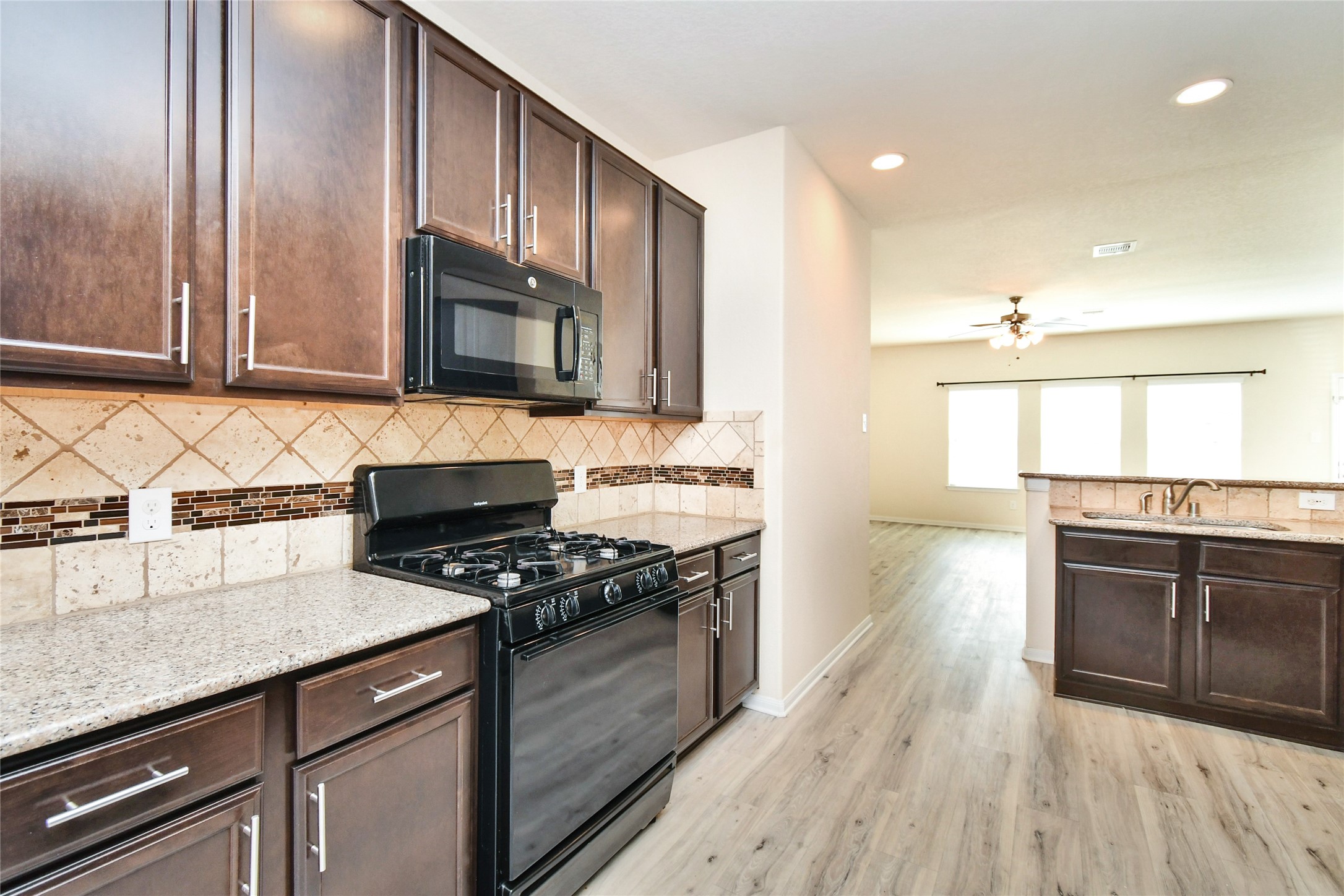 3227 Thicket Path Way Katy, TX 77493 - Photo 5 of 40 a kitchen with stainless steel appliances granite countertop a stove a sink and a microwave