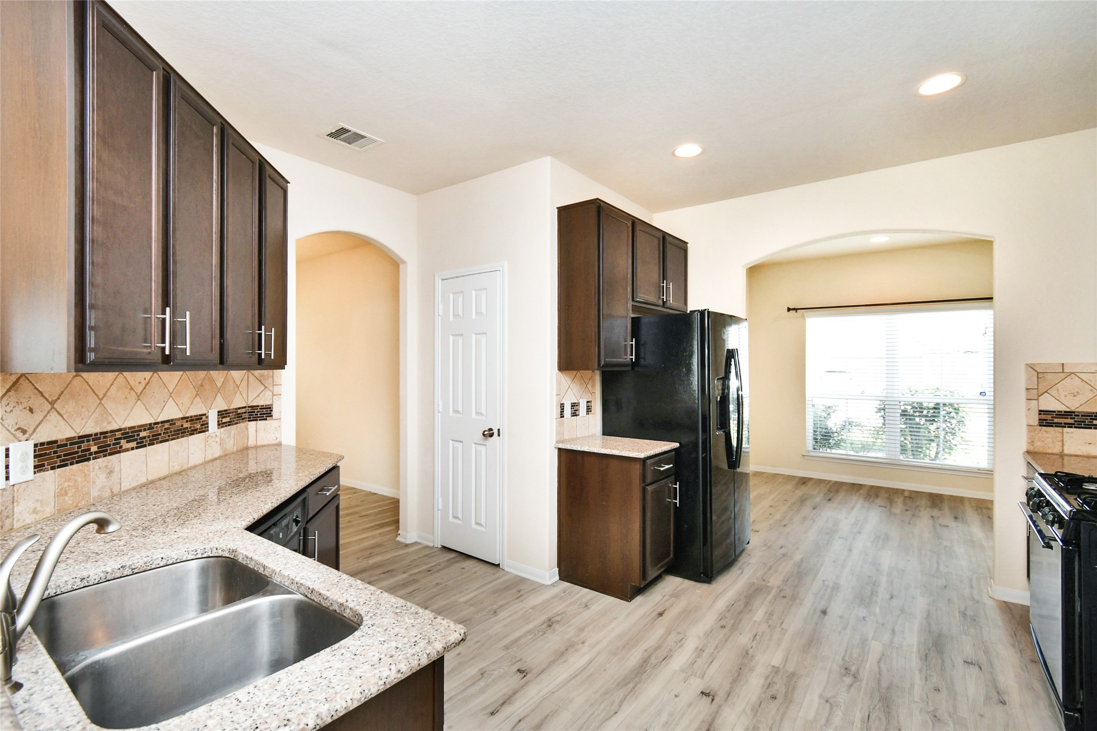 3227 Thicket Path Way Katy, TX 77493 - Photo 8 of 40 a kitchen with a sink wooden cabinets and stainless steel appliances