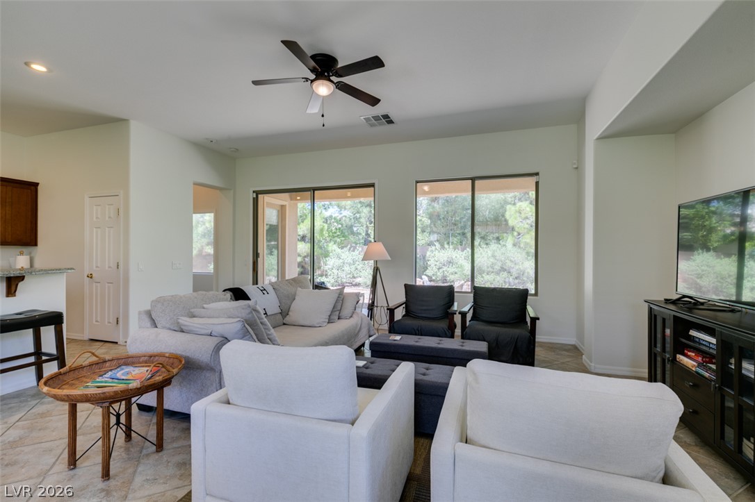 8 Kennesaw Road Henderson, NV 89052 - Photo 12 of 44 A comfortable living space offering serene backyard views through ample sliding doors.