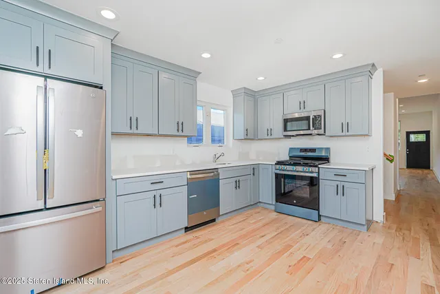 a kitchen with granite countertop white cabinets and stainless steel appliances