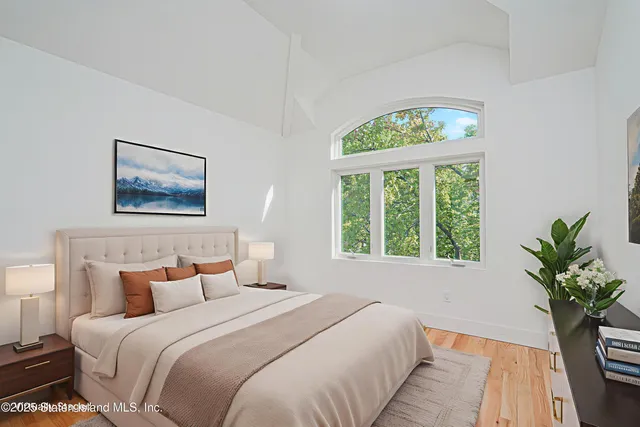 a bedroom with bed and a large window