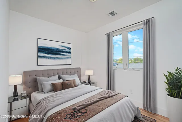 a bedroom with a bed and a painting on the wall