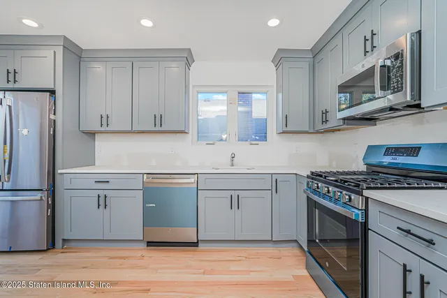 a kitchen with stainless steel appliances granite countertop a stove a sink and a refrigerator