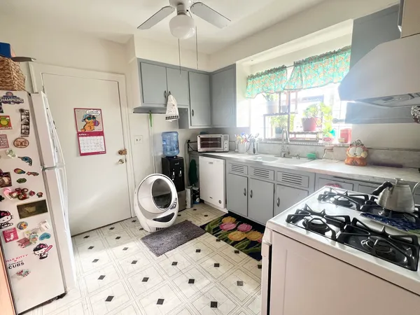a kitchen with a refrigerator a stove top oven a sink and a window