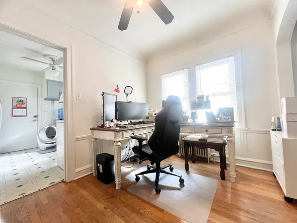 a view of a workspace with furniture and a window