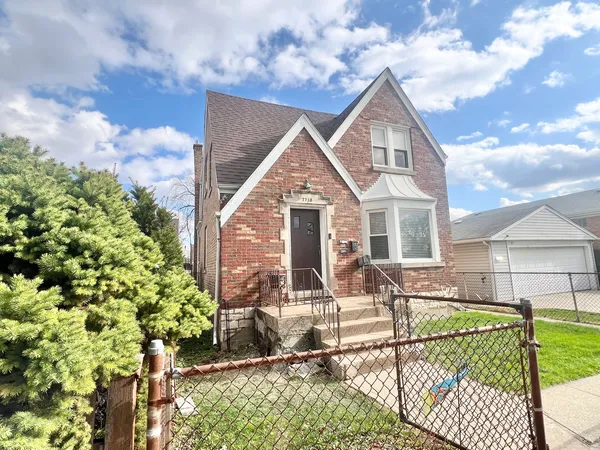 a view of a house with wooden fence next to a yard