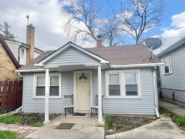 a front view of a house with a tree