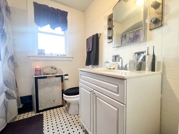 a bathroom with a sink toilet and window