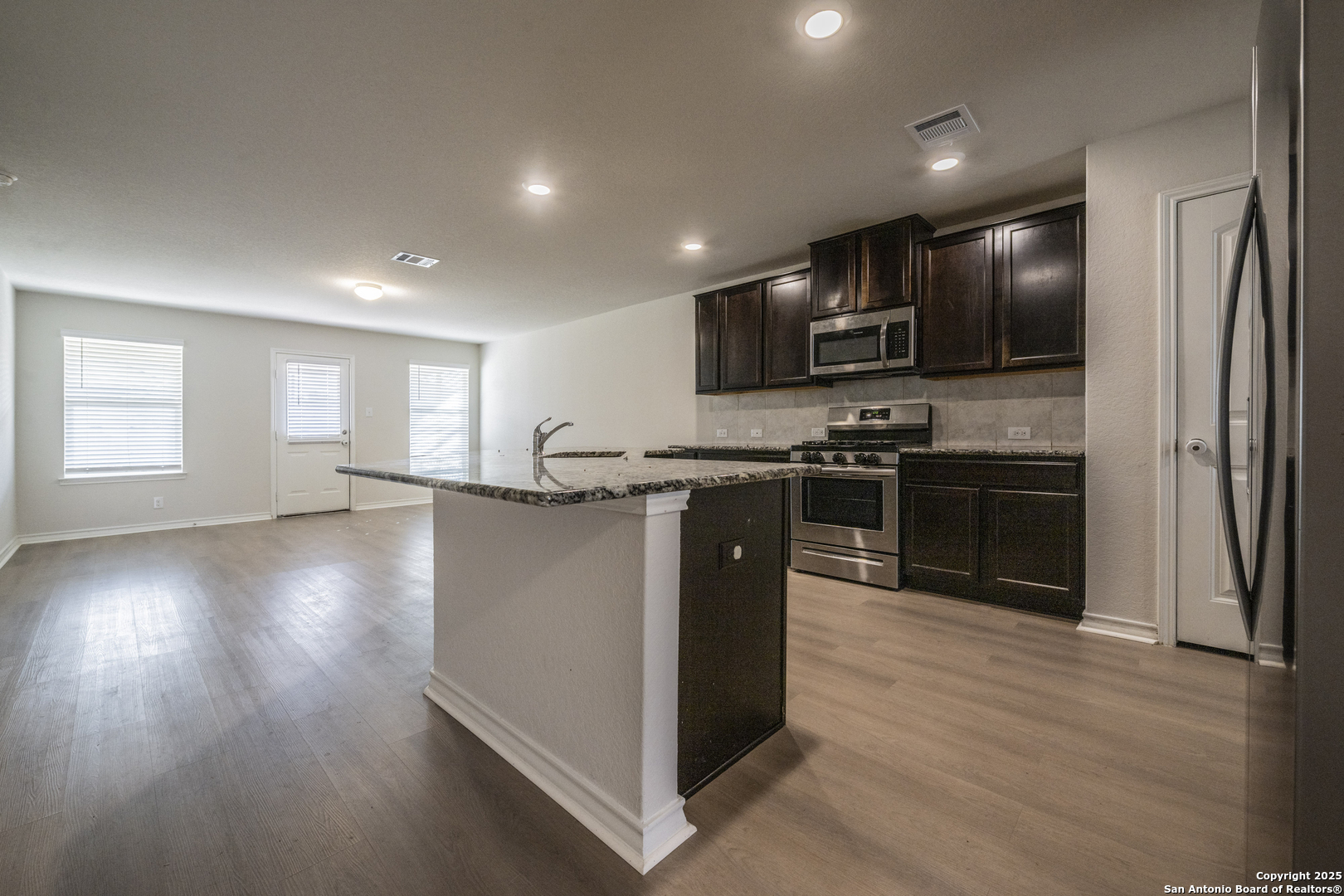 5914 Lazo Valley San Antonio, TX 78244 - Photo 14 of 40 a kitchen with stainless steel appliances granite countertop a stove a sink and a refrigerator
