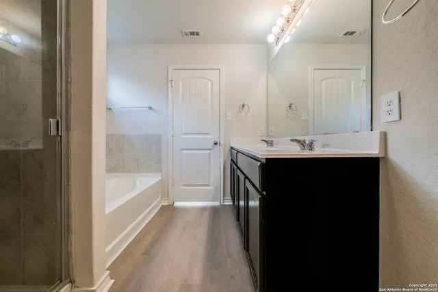 a bathroom with a tub sink and mirror