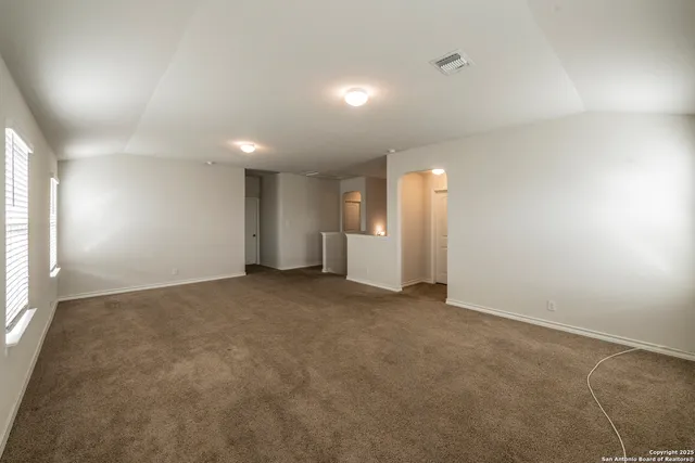 an empty room with a lamp and window