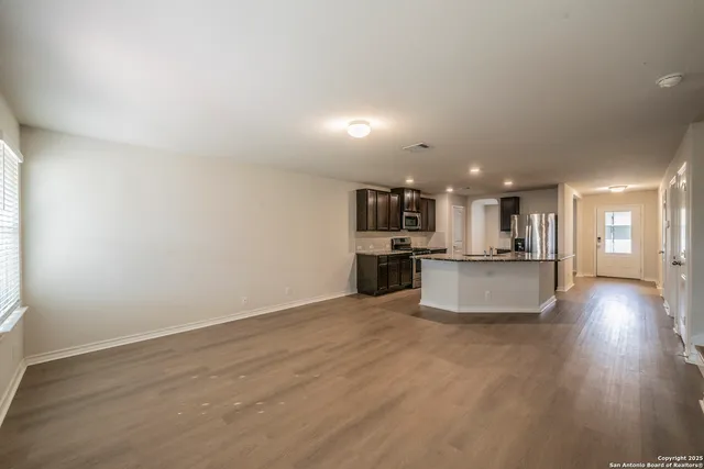 a view of kitchen with kitchen island wooden floor and center island
