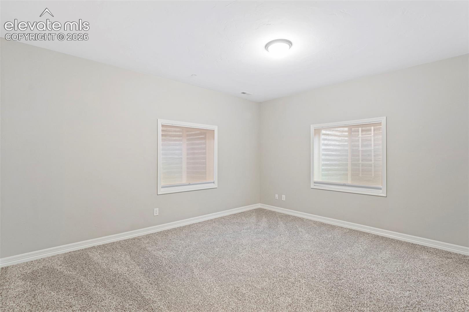 5375 Old Star Ranch View Colorado Springs, CO 80906 - Photo 35 of 47 Neutral-toned room featuring light gray walls, plush gray carpet, white baseboards, and two windows with white trim
