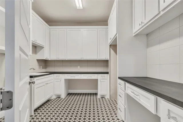 a kitchen with granite countertop white cabinets and sink