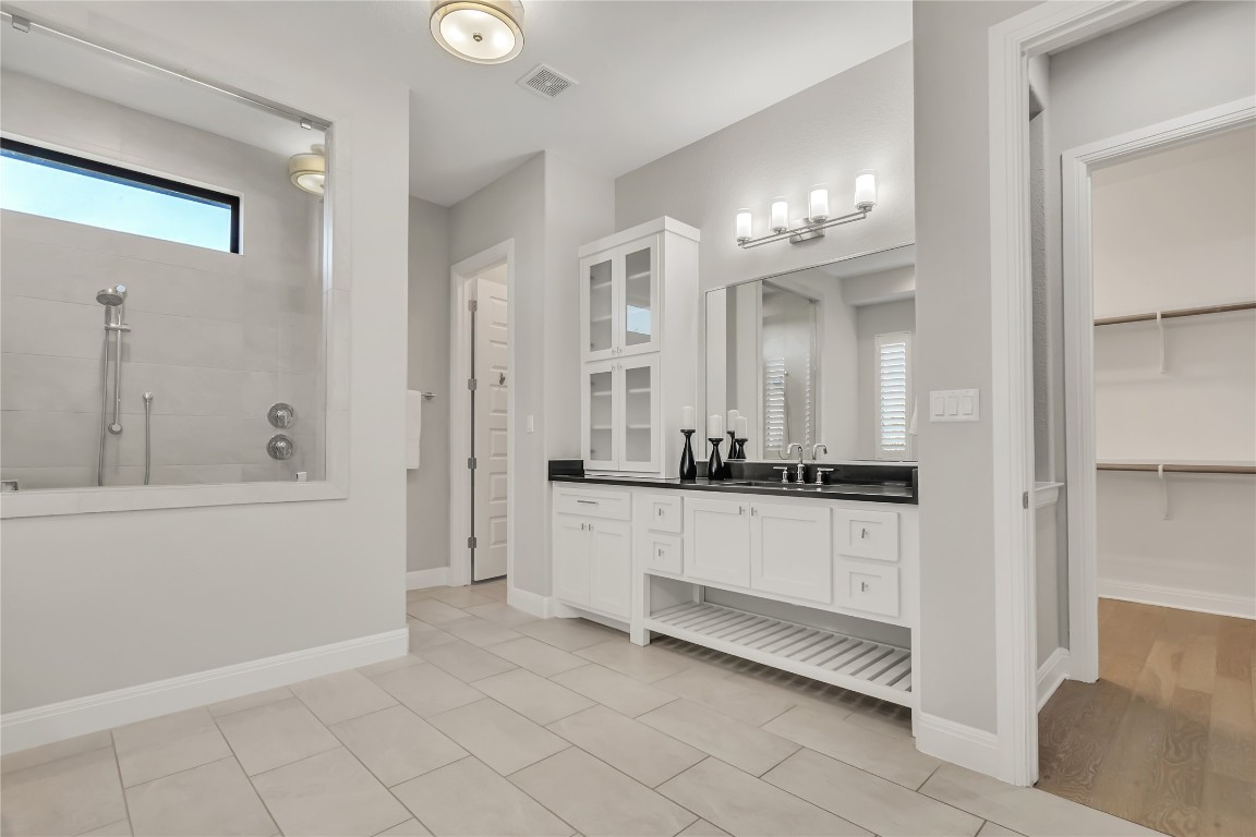 1700 Jackpot Run Leander, TX 78641 - Photo 22 of 40 a large white bathroom with a double vanity sink a mirror and a bathtub