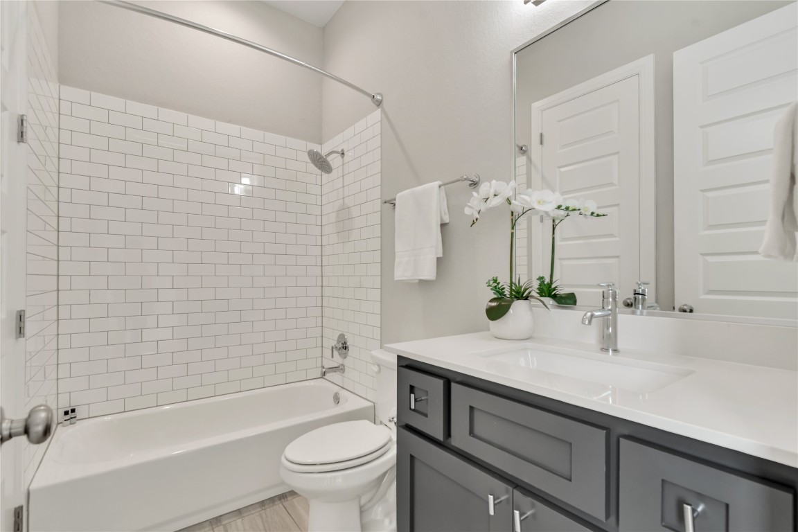 1700 Jackpot Run Leander, TX 78641 - Photo 33 of 40 a bathroom with a granite countertop sink a toilet and bathtub