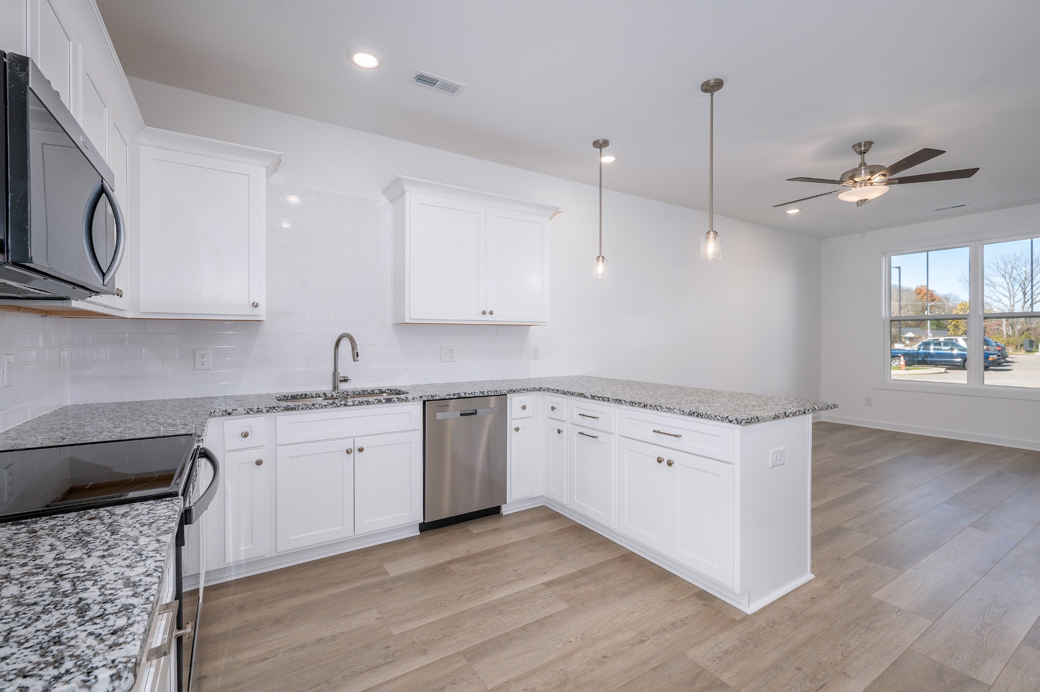 a kitchen with granite countertop a stove a sink a center island and wooden floor