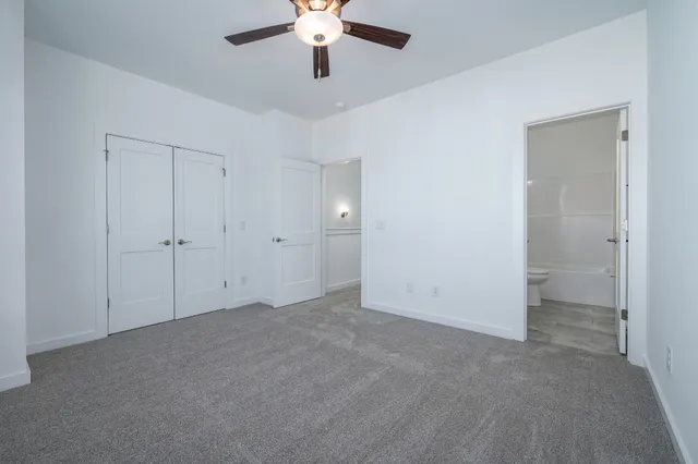 an empty room with chandelier fan