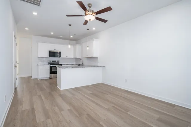 a view of kitchen with granite countertop cabinets and stainless steel appliances