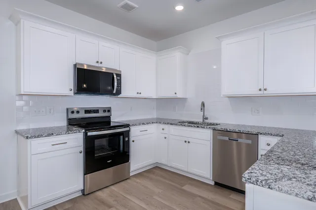 a kitchen with granite countertop a sink and steel appliances