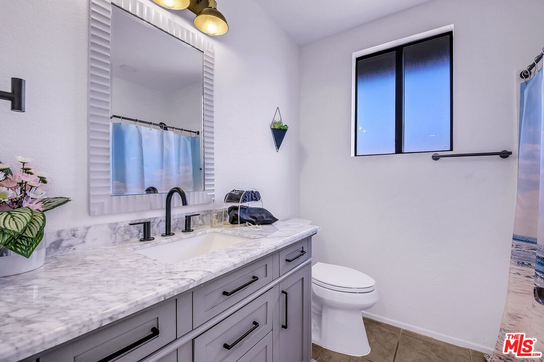 45808 Sutter Creek Road Indio, CA 92201 - Photo 25 of 33 a bathroom with a granite countertop toilet sink and mirror