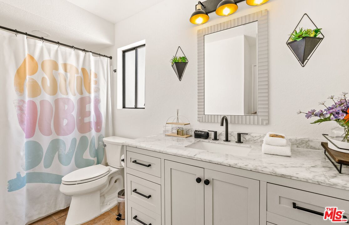45808 Sutter Creek Road Indio, CA 92201 - Photo 27 of 33 a bathroom with a granite countertop sink a toilet and a mirror