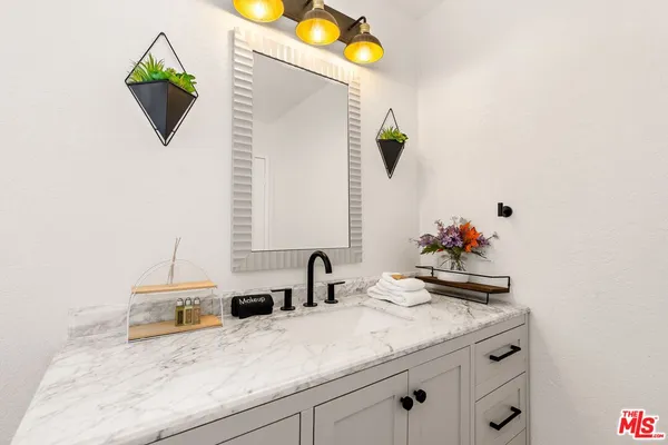a bathroom with a granite countertop sink and a mirror