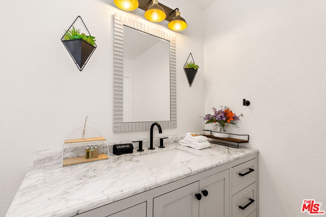 45808 Sutter Creek Road Indio, CA 92201 - Photo 28 of 33 a bathroom with a granite countertop sink and a mirror