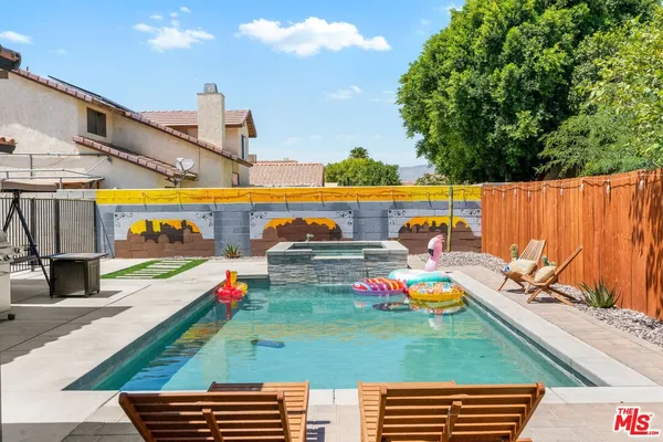 a view of swimming pool with chairs and yard