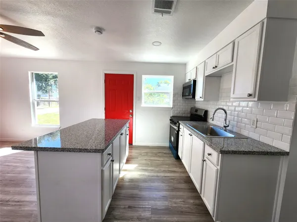 a kitchen with granite countertop a sink and a stove