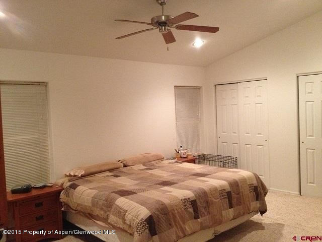 300 Columbine Drive Rifle, CO 81650 - Photo 3 of 8 a bedroom with a bed and a ceiling fan