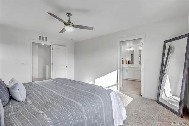 a bedroom with a bed and a refrigerator