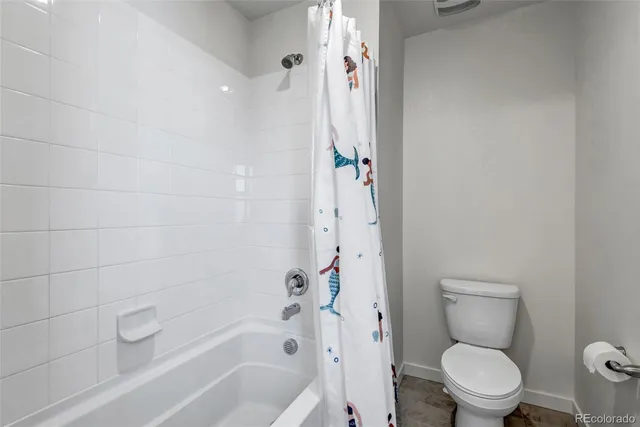 a white toilet sitting next to a bath tub