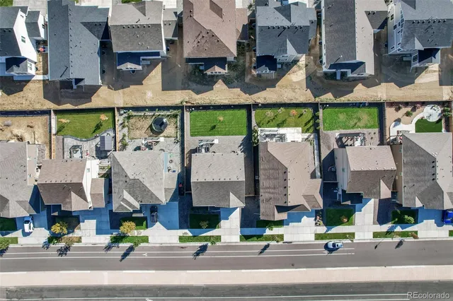 an aerial view of residential houses with outdoor space and ocean view