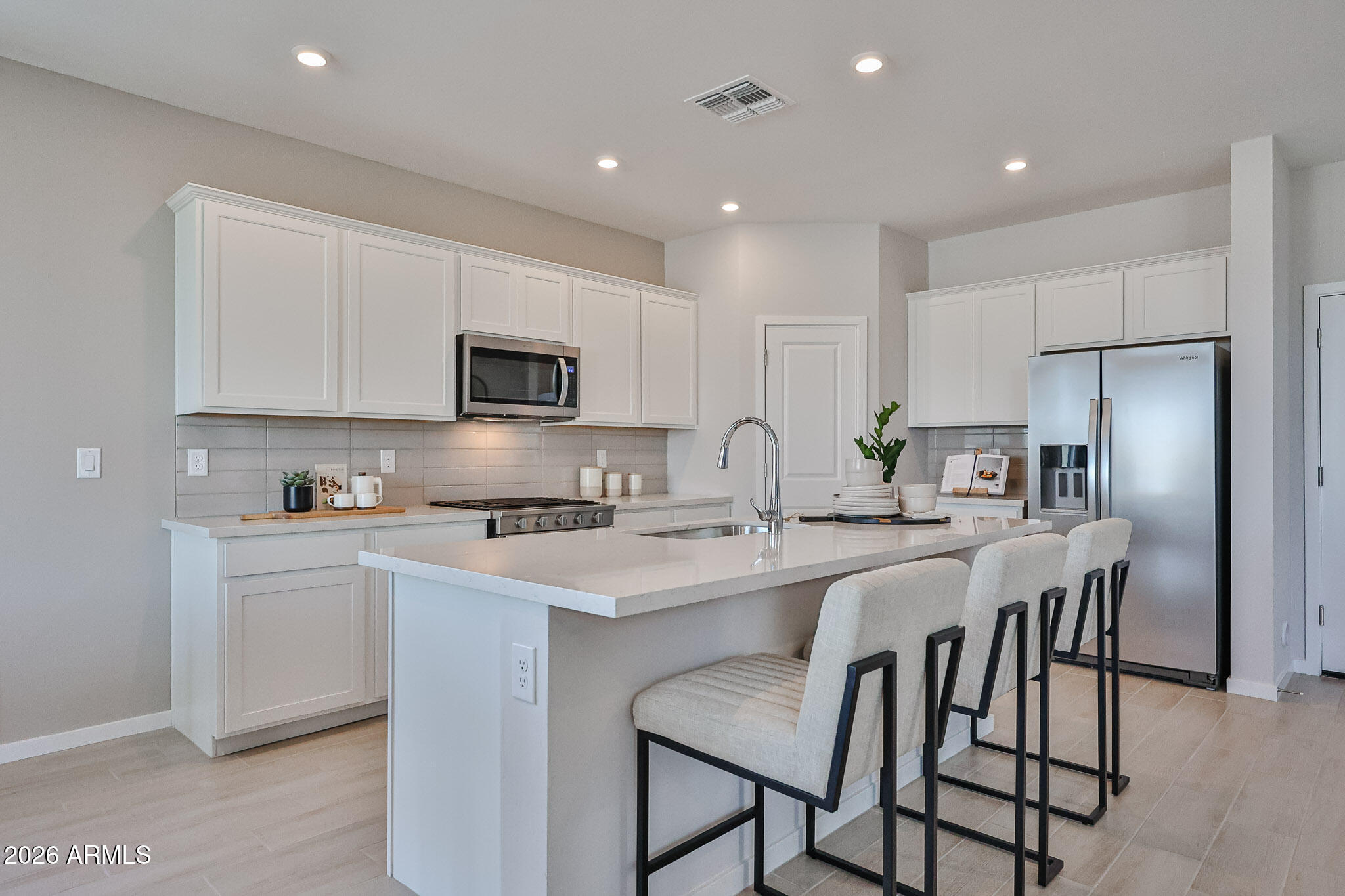 12466 North 305th Avenue Buckeye, AZ 85396 - Photo 14 of 51 a kitchen with stainless steel appliances granite countertop a stove a sink a microwave a refrigerator and white cabinets with wooden floors