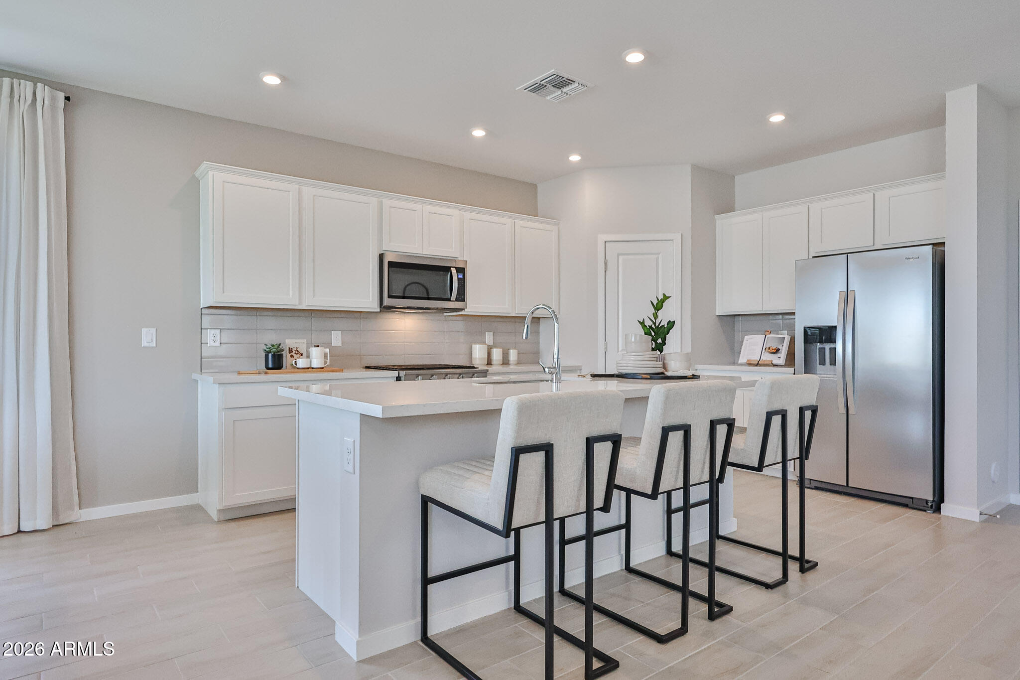 12466 North 305th Avenue Buckeye, AZ 85396 - Photo 44 of 51 a kitchen with kitchen island granite countertop a stove a sink a refrigerator with a dining table and chairs