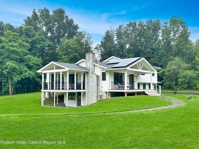 a view of a house with backyard and sitting area