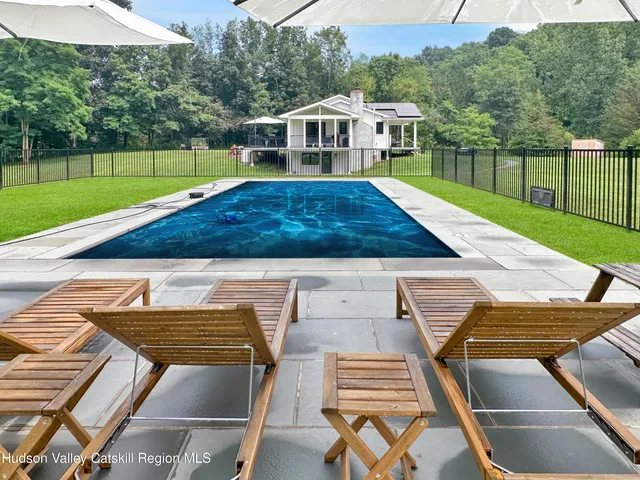 a view of a house with backyard and sitting area