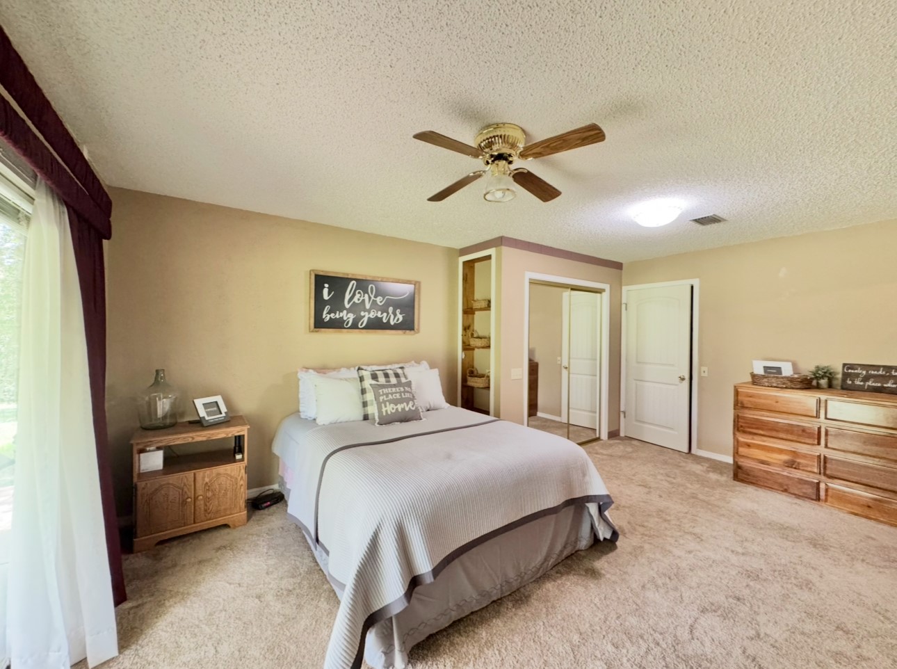 702 Pleasant Grove Road Elgin, TX 78621 - Photo 19 of 38 Carpeted bedroom featuring a ceiling fan and a textured ceiling