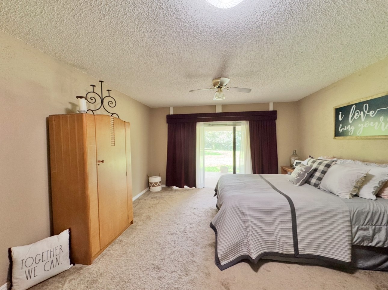 702 Pleasant Grove Road Elgin, TX 78621 - Photo 21 of 38 Carpeted bedroom with ceiling fan, a textured ceiling, and access to outside