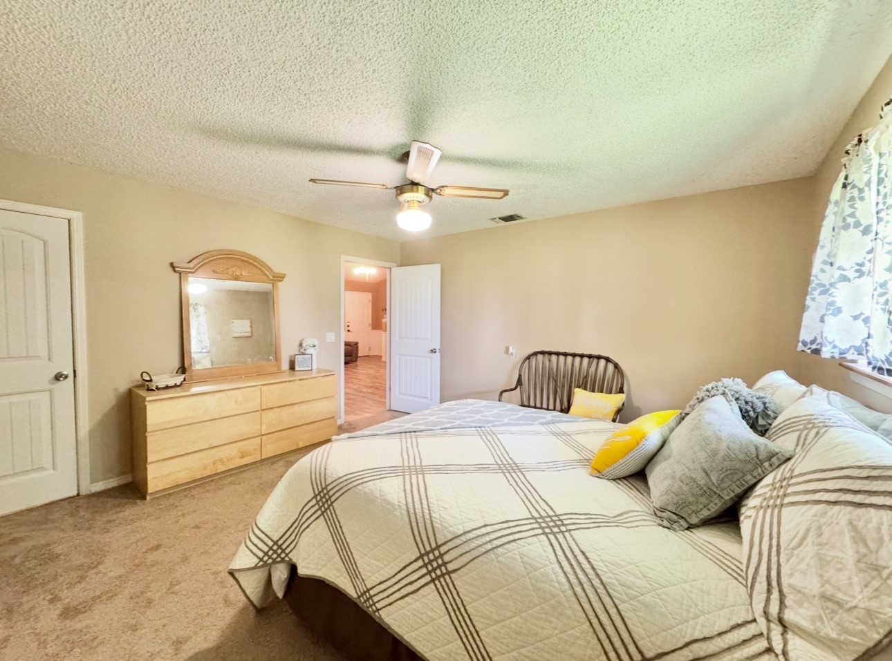 702 Pleasant Grove Road Elgin, TX 78621 - Photo 28 of 38 Bedroom with light colored carpet, ceiling fan, and a textured ceiling