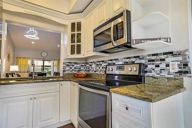 a kitchen with stainless steel appliances granite countertop a stove and a sink