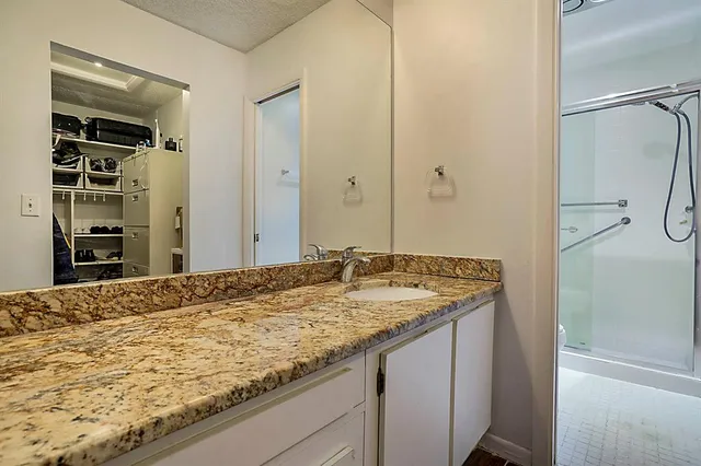 a bathroom with a granite countertop sink and a mirror