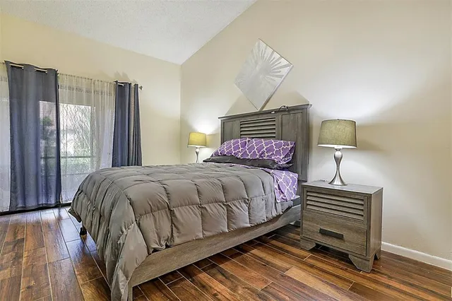 a bedroom with a bed and wooden floor