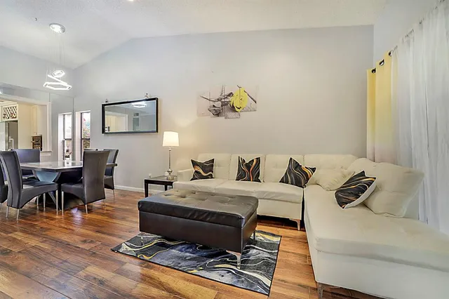 a living room with furniture and wooden floor