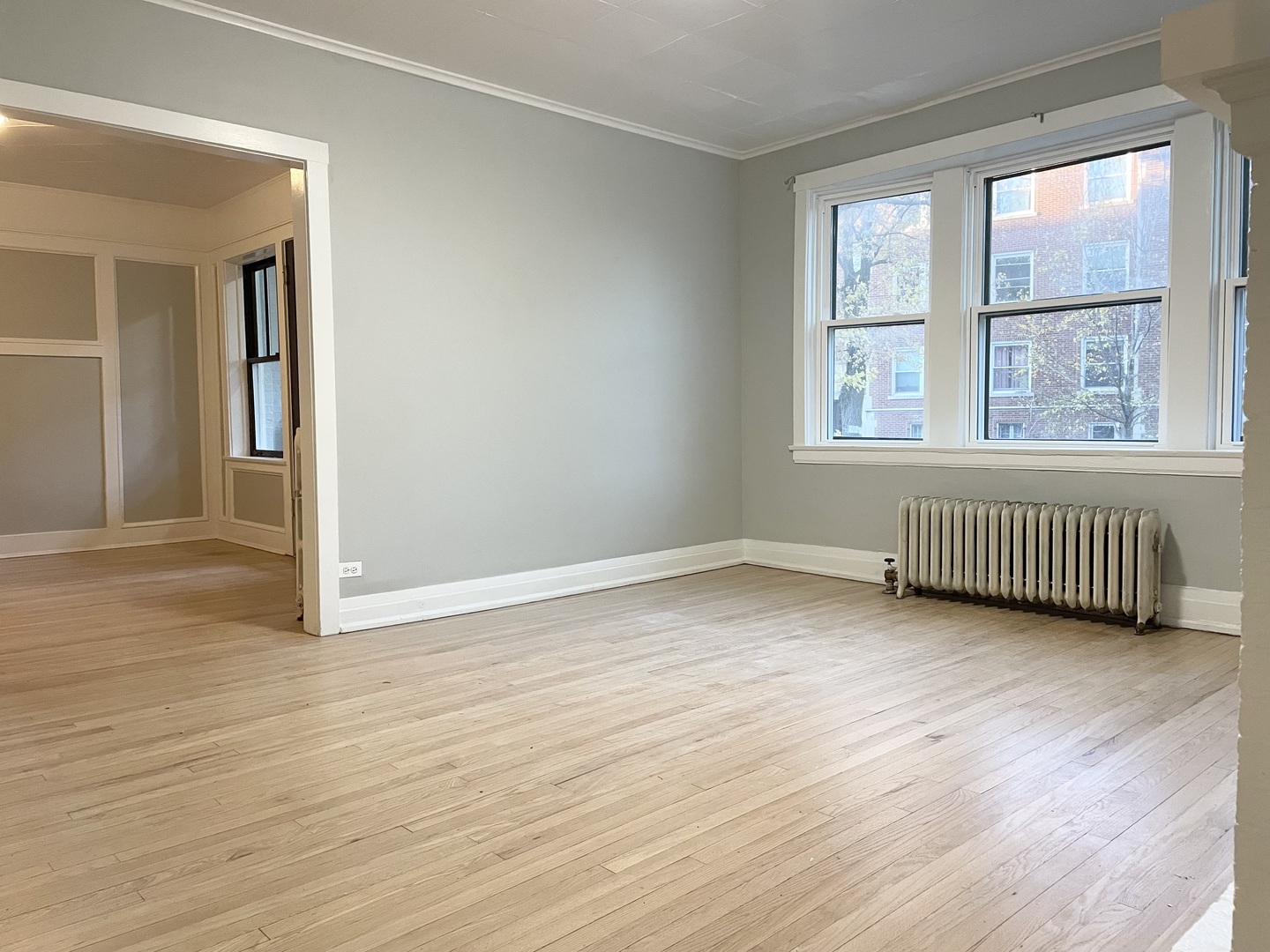 7077 North Ridge Boulevard, Unit 1S Chicago, IL 60645 - Photo 4 of 17 a view of an empty room with wooden floor and a window