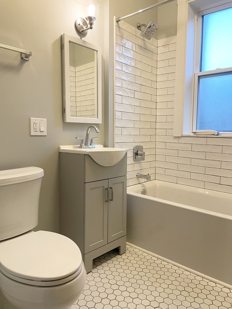7077 North Ridge Boulevard, Unit 1S Chicago, IL 60645 - Photo 8 of 17 a bathroom with a sink toilet and bathtub