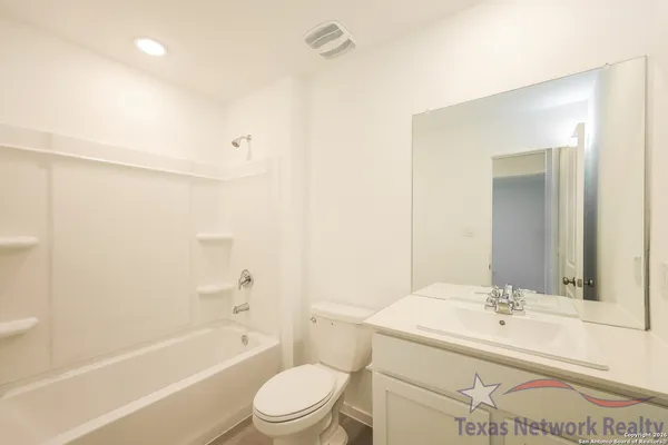 a bathroom with a granite countertop sink a toilet and shower